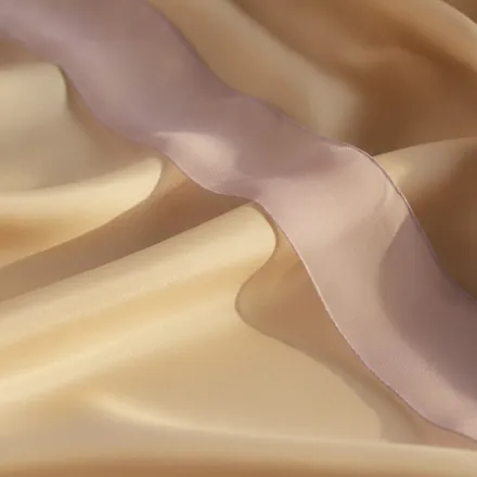Macro of draped ivory silk with a lilac organza ribbon